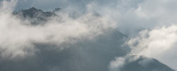 Fototapeta na wymiar Mountain peaks in the clouds, foggy morning 