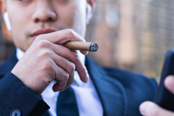Cropped businessman smoking cigar - obrazy, fototapety, plakaty