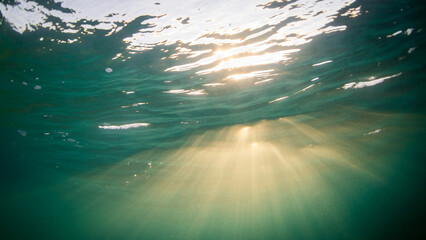 Beautiful sun rays penetrate through the ocean surface.