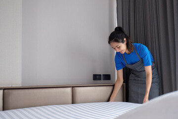 beautiful cleaning lady Clean and prepare the bedding on the bed diligently.