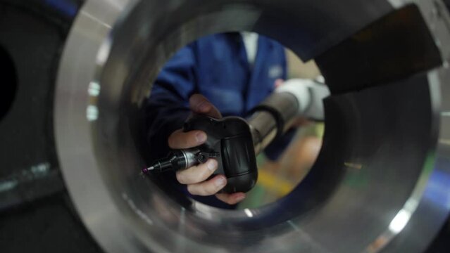 Tech expert utilizes portable CMM with precision Romer arm, probe in metalworking. Detailed inspection ensures accuracy in industrial fabrication. Engineer engages in meticulous quality control.