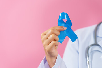 Prostate cancer awareness. Close up medical doctor holding ribbon over pink background isolated....