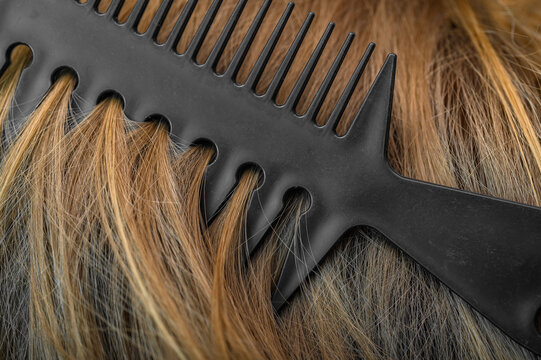 Cienkie i zniszczone blond włosy z rozdwojonymi końc&oacute;wkami i plastikowy grzebień 