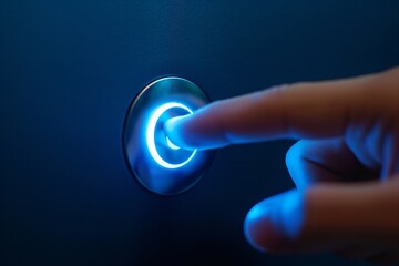 Close-up of a finger pressing a glowing blue power button on a dark background. - obrazy, fototapety, plakaty