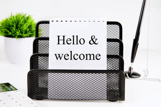 Hello and welcome text on a white sheet of a notebook in a black stand. Concept photo