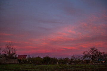 Obraz premium Beautiful sunset in the countryside with purple sky and red clouds