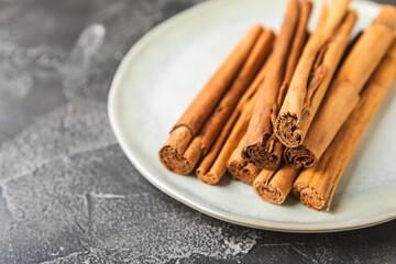 Ceylon cinnamon.Cinnamon sticks on a textured wooden background. Cinnamon roll and powder. Spicy spice for baking, desserts and drinks. Fragrant ground cinnamon. Close-up. Place for text. copy space