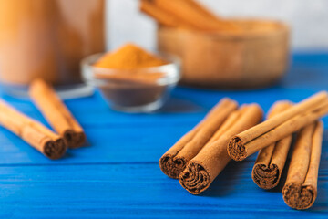 Ceylon cinnamon.Cinnamon sticks on a textured wooden background. Cinnamon roll and powder. Spicy spice for baking, desserts and drinks. Fragrant ground cinnamon. Close-up. Place for text. copy space