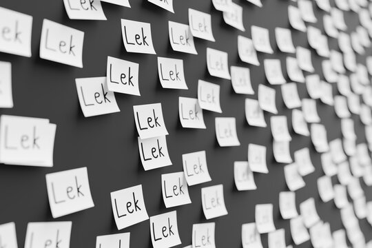 Many white stickers on black board background with symbol of Albania lek drawn on them. Closeup view with narrow depth of field and selective focus. 3d render, illustration