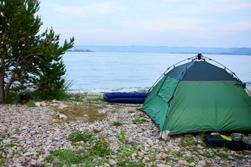 Photo sur Plexiglas Plage de Camps Bay, Le Cap, Afrique du Sud A tent on a pebble beach by the lake at dawn. A place for camping.