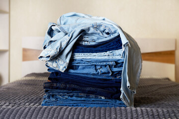 A pile of denim clothes on the bed.  
