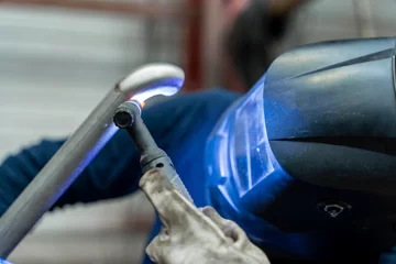 Fotobehang ouvrier en train de souder une partie en métal  © Thomas