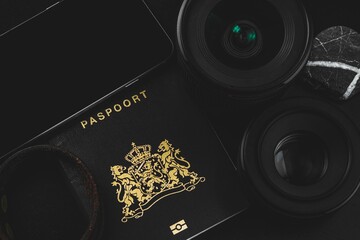 Overhead shot of travel essentials including a passport, lenses and a phone