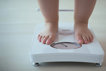 The woman is weighing herself. The concept of obesity and the importance of a healthy lifestyle.