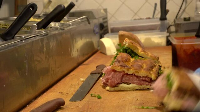 Freshly chef cook Italian sandwich in Florence bread salami slice meat vegetable and sauce