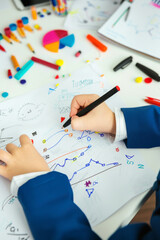 Child's Hand Drawing Colorful Graphs and Shapes on Paper