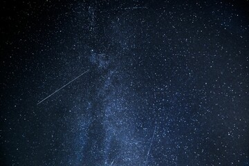 Scenic view of a shooting star in a dark blue starry night sky