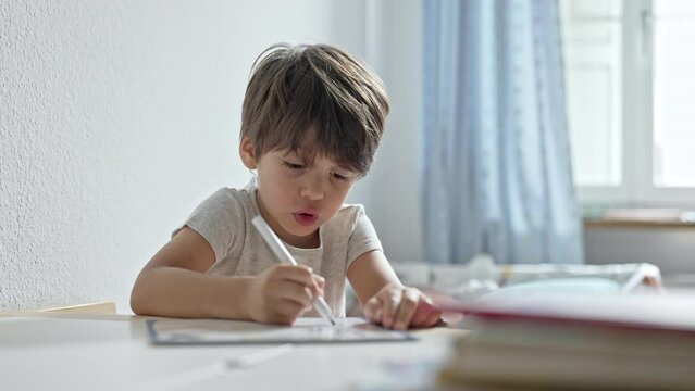Boy At Study Desk In Room, Working On Cursive Handwriting