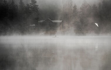 Beautiful view of the foggy Wasa Lake with a person on a boat - Powered by Adobe