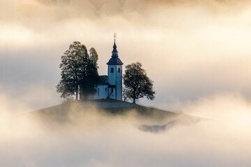 Dramatic shot of St. Thomas church in Slovenia in a foggy day