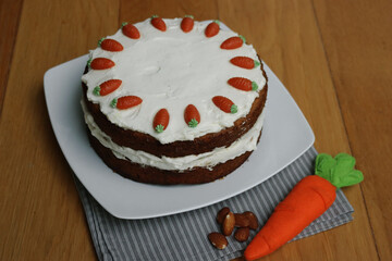 Homemade carrot cake with mascarpone cream cheese icing, mini marzipan carrot decorations and felt...