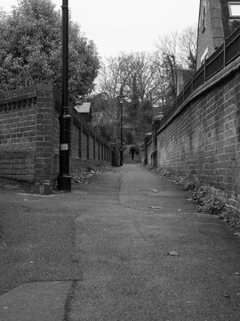 Vertical grayscale of a narrow alley, and old brick walls, in Fareham UK