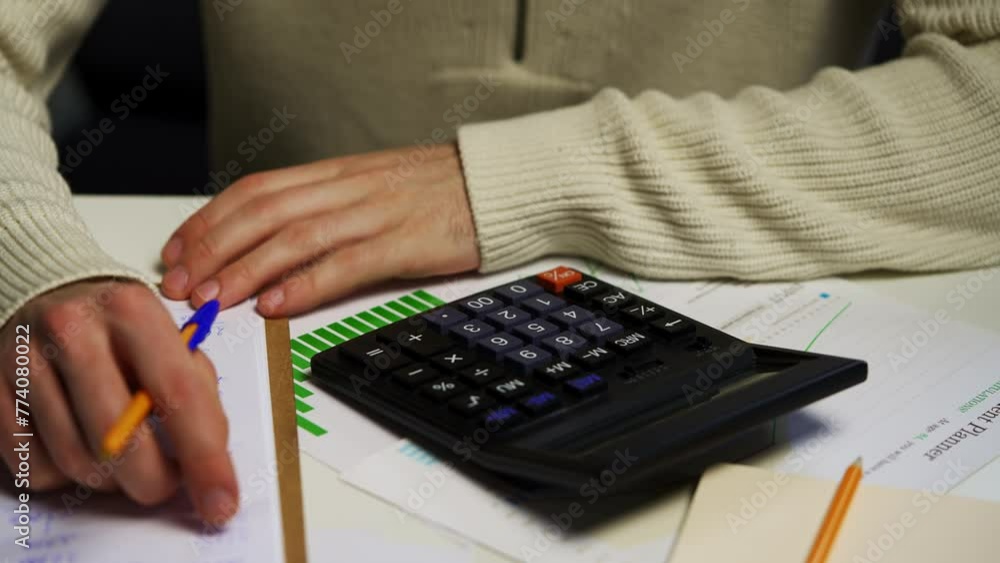 Poster man analyzing financial charts and calculating budget in home office setting