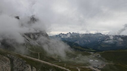 Fototapeta premium Mountain peaks of Italian Dolomites hiding behind the fog