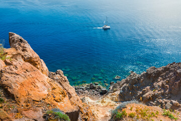 Santorini island, Greece. Yacht sailing near the sea coast.