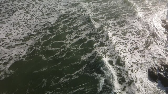 Aerial view of the splashing waves of the sea on a gloomy day