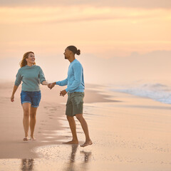 Couple In Casual Clothing On Vacation Holding Hands Walking Along Beach Shore At Dawn