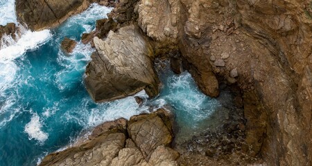 Brown cliffs and beautiful turquoise sea waves.