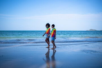 LGBTQ couple lover holding hand pose happiness life on beach in summer holidays vacation is friendship freedom equality of love concept. - obrazy, fototapety, plakaty