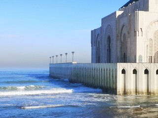 Exterior of Hassan II Mosque by the sea with blue sky in Casablanca, Morocco