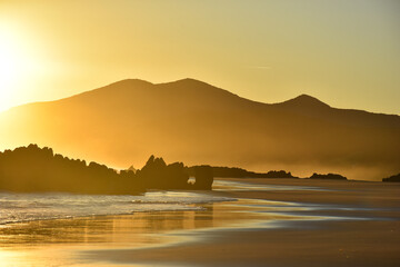 Sunrise on Noja beach in Cantabria, Spain. Golden beautiful sunrise on Noja - obrazy, fototapety, plakaty
