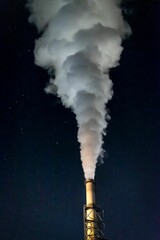 Vertical closeup shot of chimney emitting smoke on the background of the starry sky