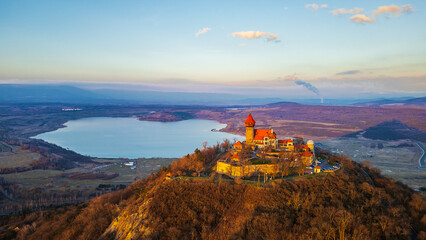 Neo-Gothic castle Hněvín at sunset. Dominant of the city of Most. Taken by drone. Lake Most and...