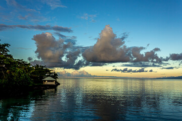 White Cumulostratus or Cumulus clouds over a lagoon on Samoa island, illuminated by the bright sun...