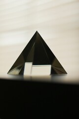 Vertical macro shot of a transparent crystal prism against the isolated background
