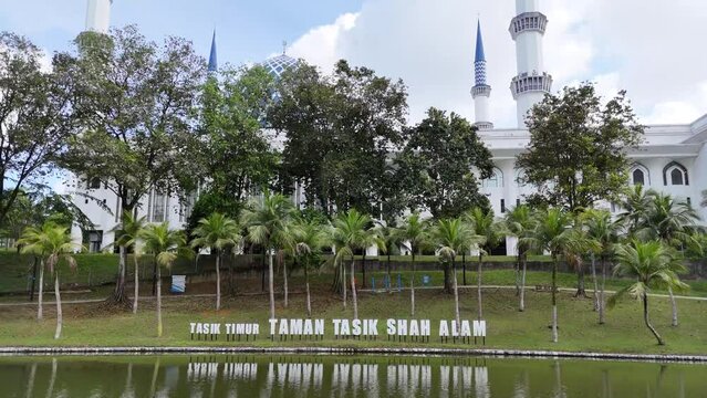 Zoom out shot of a mosque with the words "Tasik Timur Taman Tasik Shah Alam" visible in front of it.