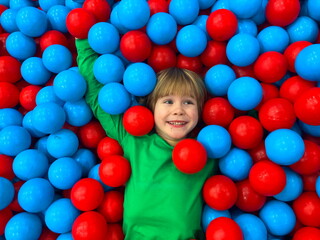 Fototapeta na wymiar Cute smiling boy in ball pool looking at camera
