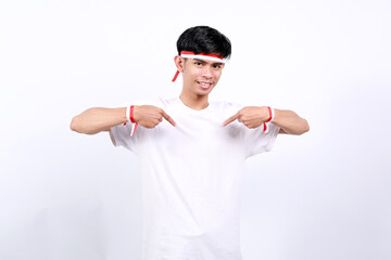 Naklejka premium Young asian boy with red white ribbon celebrating Indonesia independence day while pointing at himself