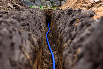 Earth trench dug to lay pipe or optical fiber.