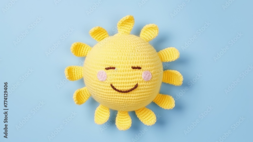 Wall mural Knitted, cute sun with a smile on a blue background, top view, with space for text. Greeting card, hobbies, knitting, children's toys.