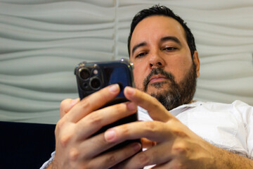 Latin man with beard working on his smartphone in Neiva – Huila - Colombia