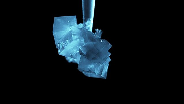 Glowing blue growing crystal macro close up time lapse