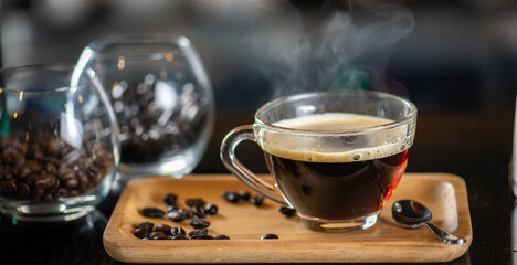 black drip coffee in glass cup, Barista making drip coffee by pouring spills hot water on coffee bean. Barista serve holding cup of hot black coffee or americano for serve on wooden table cafe shop