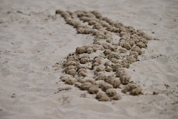 Diagonal, handformend sand balls at the beach of Benidorm-Spain. A creative result of playing children.