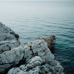 Fototapeta na wymiar Tranquil Coastal Seascape with Rocky Shoreline and Calm Blue Ocean at Dusk