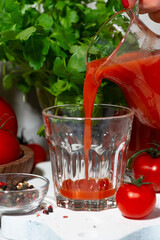 fresh tomato juice poured into a glass, vertical